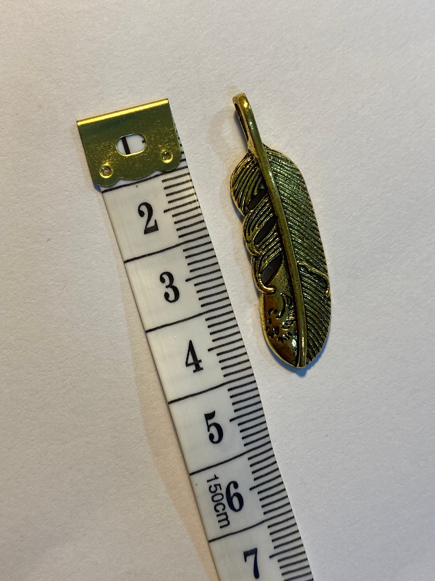 Dijes de pluma dorados 4 cm de largo