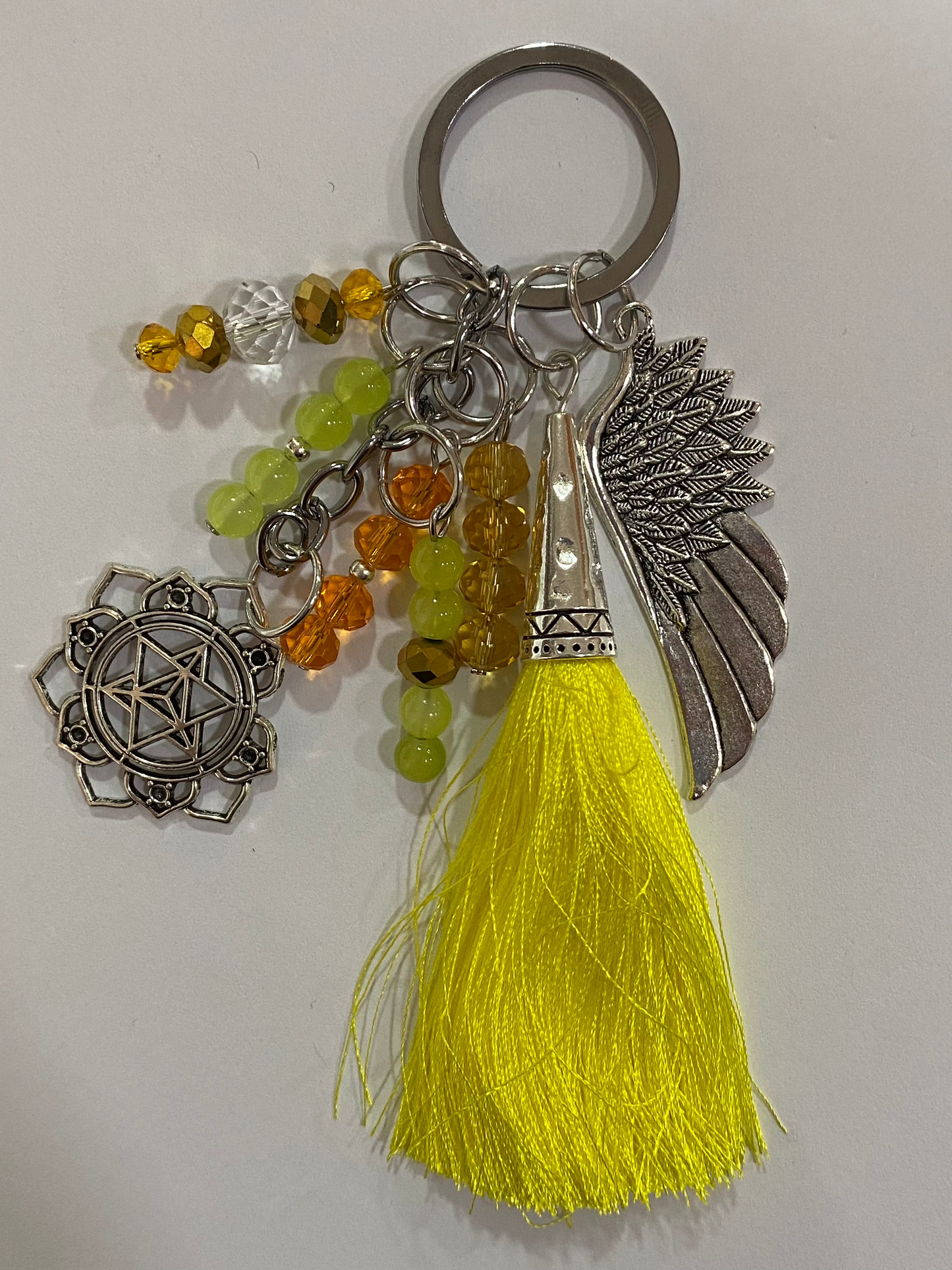 Llavero en tonos amarillos con ala y chakra