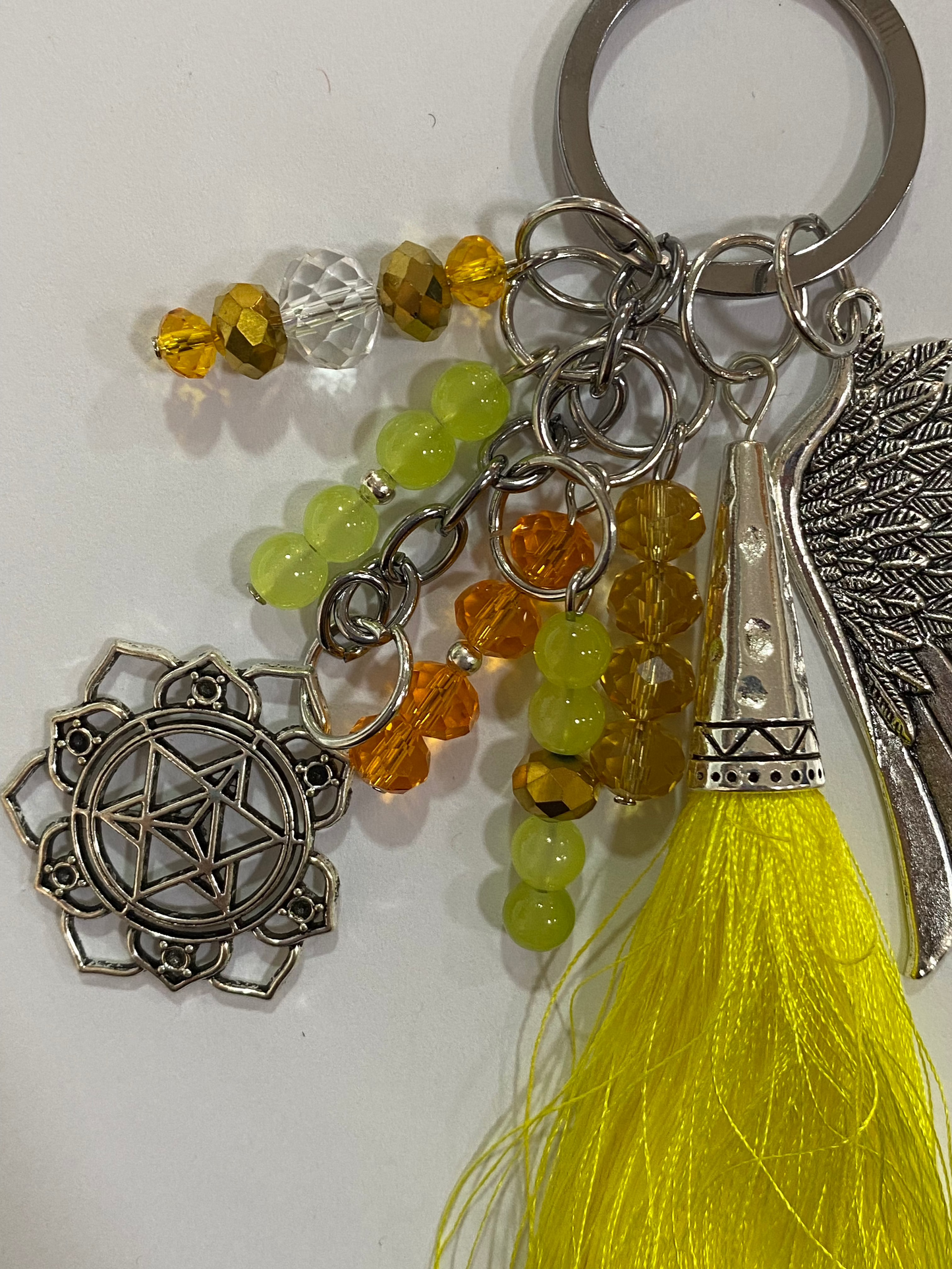 Llavero en tonos amarillos con ala y chakra