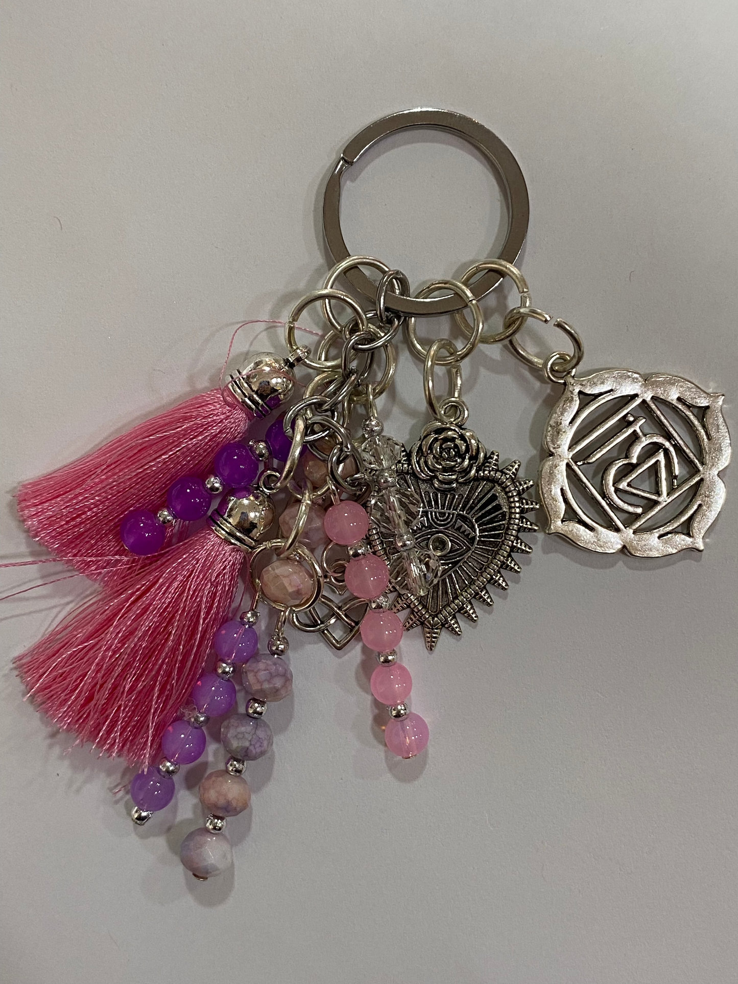 Llavero en tonos lilas y rosas con corazón y chakra