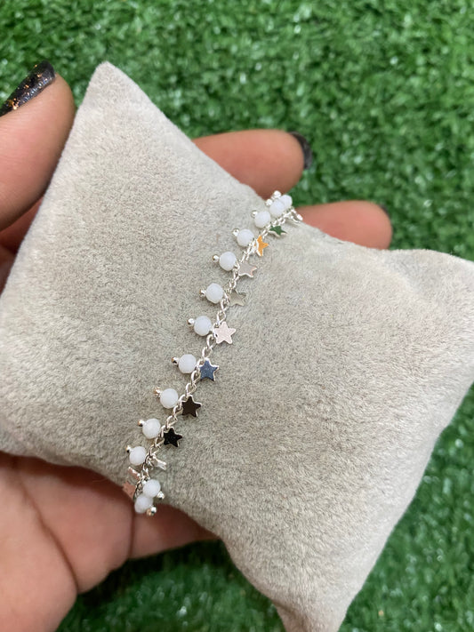 Pulsera plateada con cuentas blancas y estrellas con baño en plata