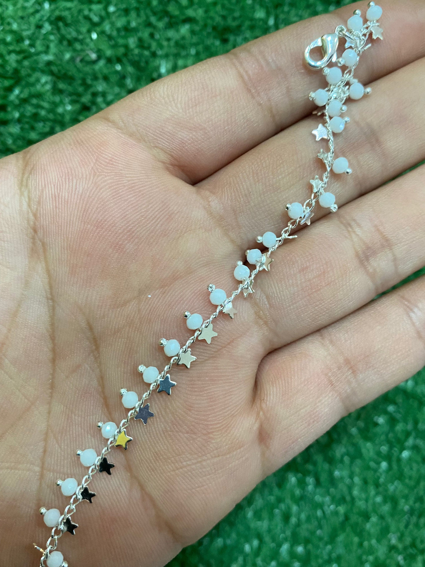 Pulsera plateada con cuentas blancas y estrellas con baño en plata