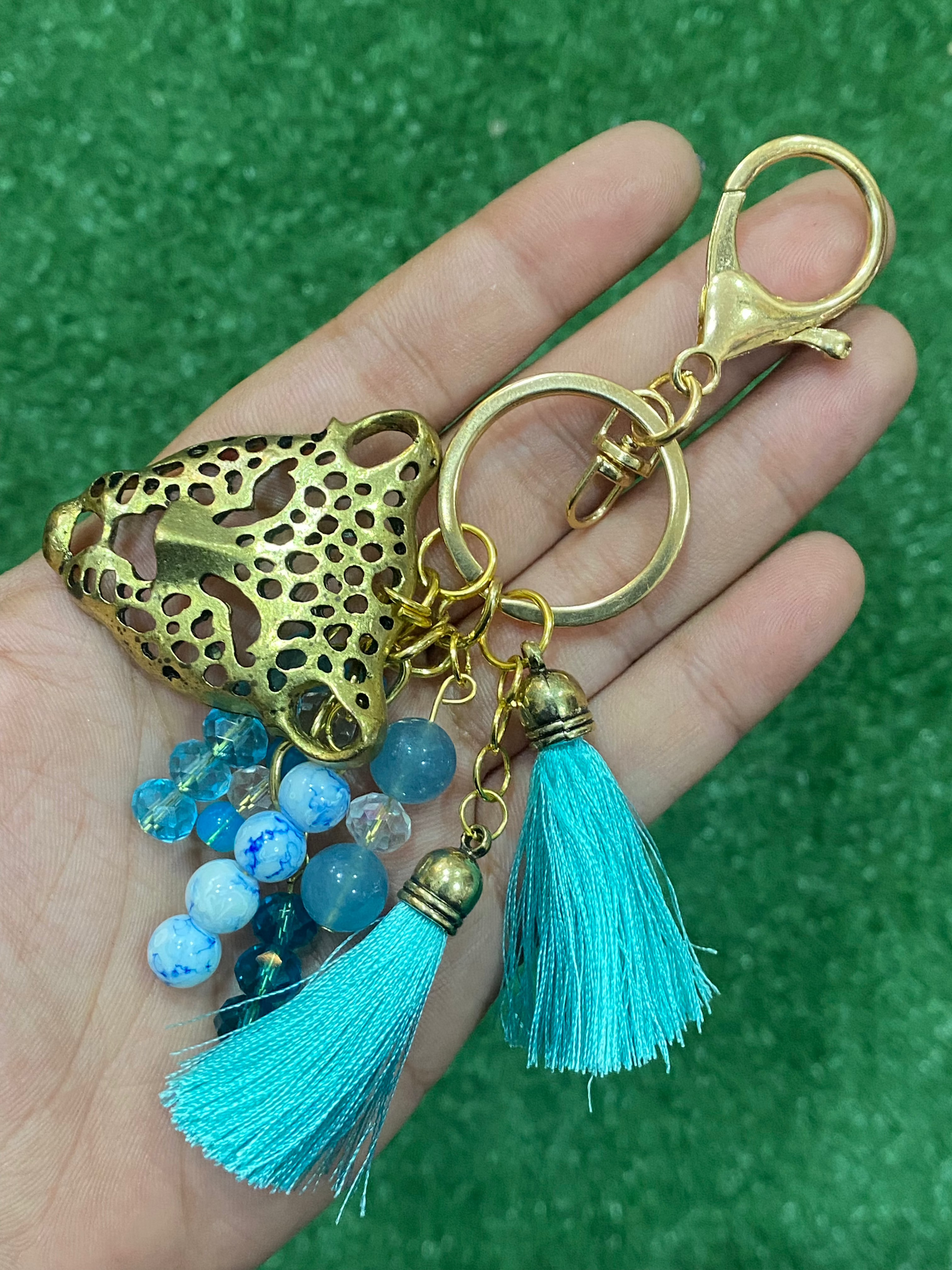Llavero en tonos celestes con pieza central de leopardo dorado