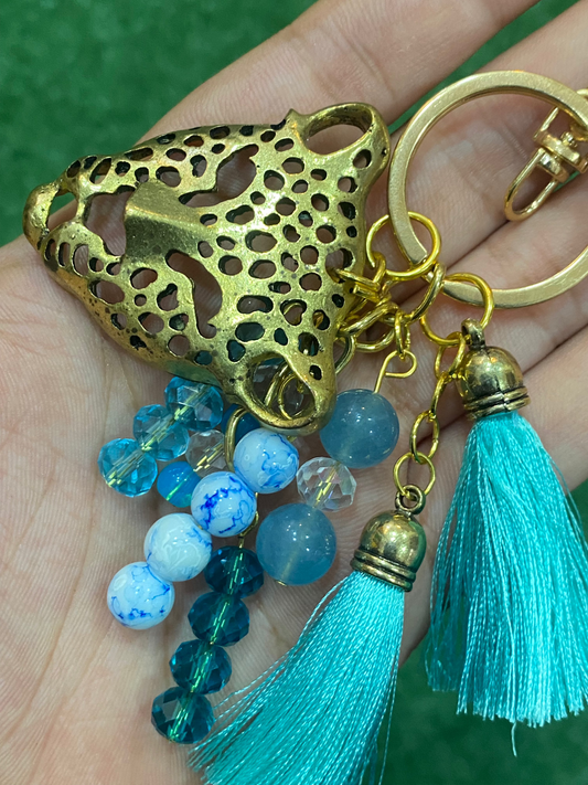 Llavero en tonos celestes con pieza central de leopardo dorado