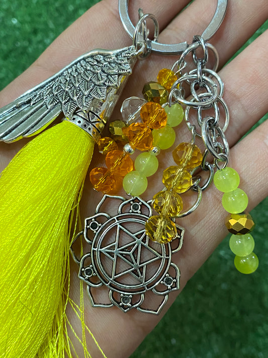Llavero en tonos amarillos con ala y chakra