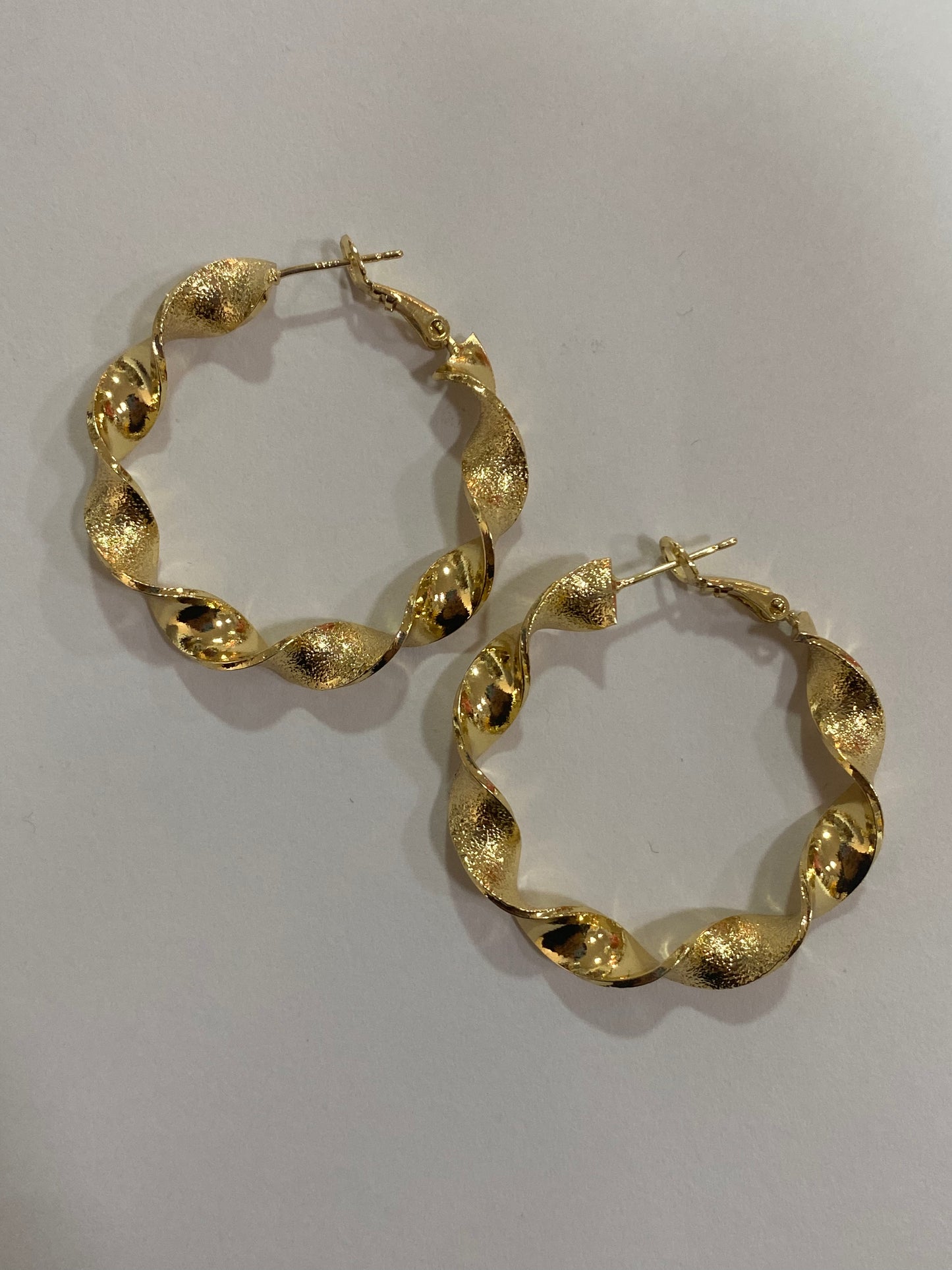 Argollas enroscadas doradas con baño en oro