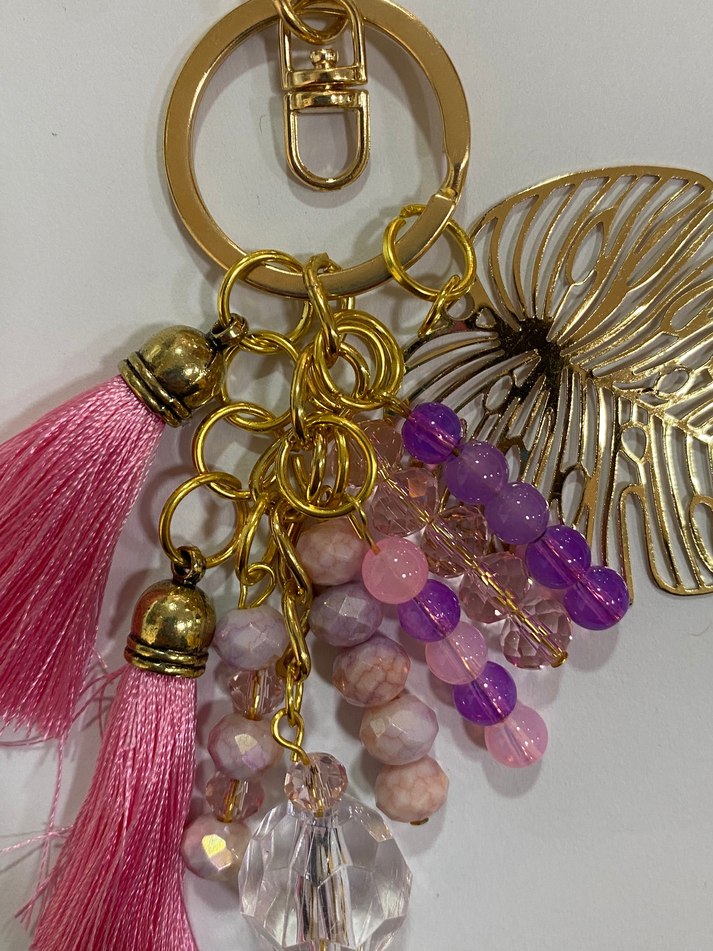 Llavero en tonos lilas y rosas con hoja central