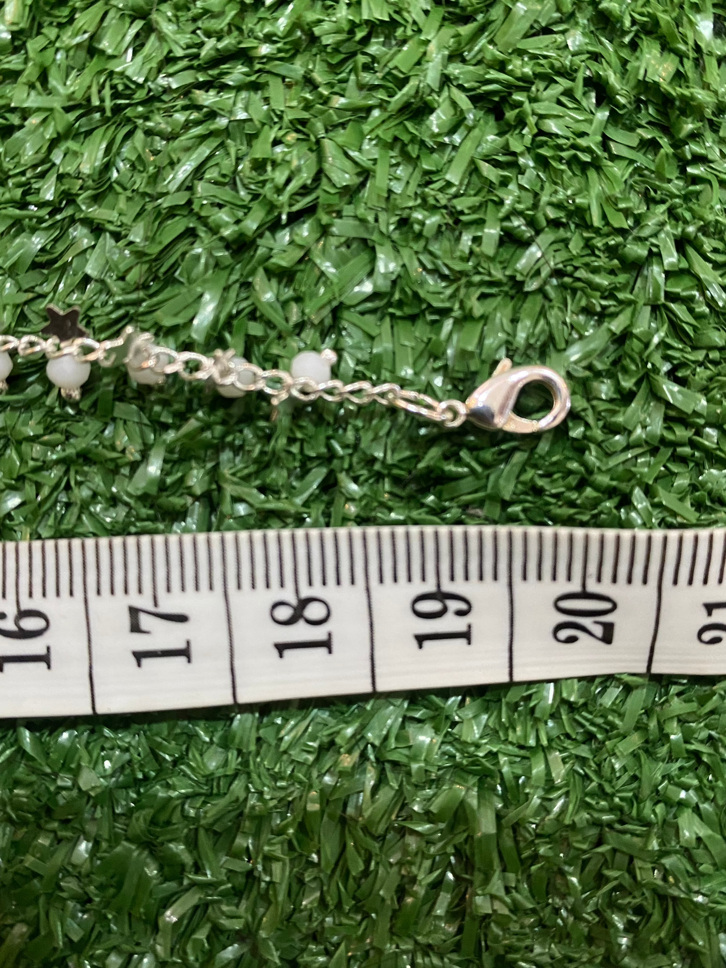 Pulsera plateada con cuentas blancas y estrellas con baño en plata