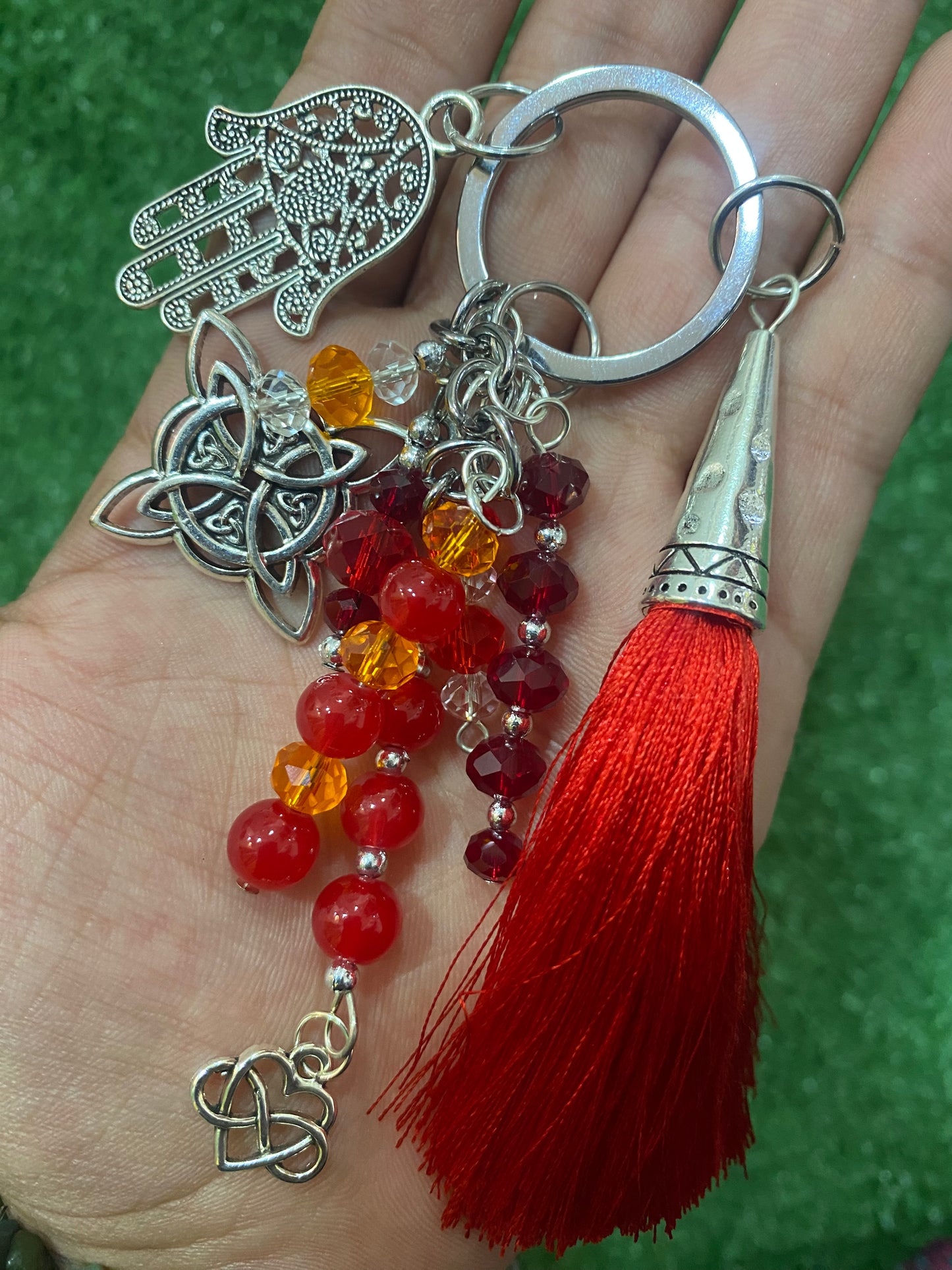 Llavero en tonos rojos con mano de Fátima y nudo de bruja plateados