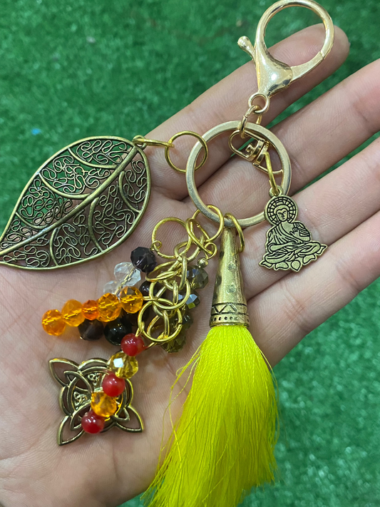 Llavero en tonos amarillos con hoja, nudo de bruja y buda