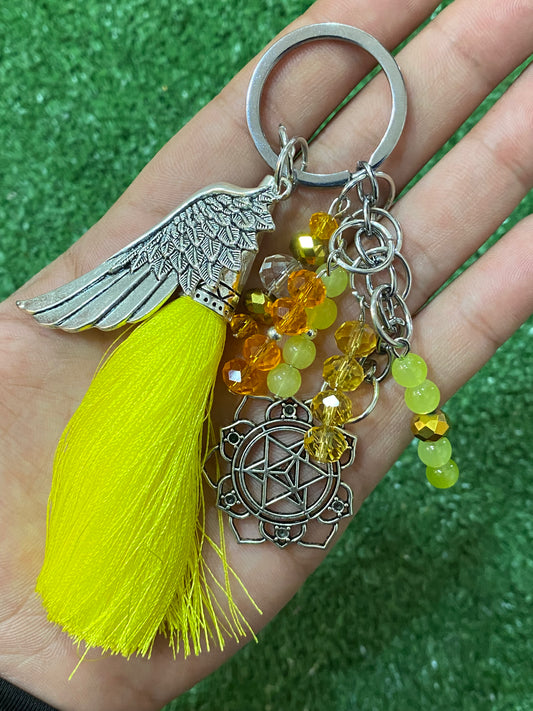Llavero en tonos amarillos con ala y chakra